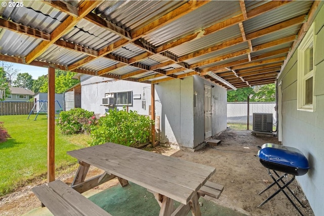 view of patio / terrace featuring a playground, central AC unit, a grill, and fence
