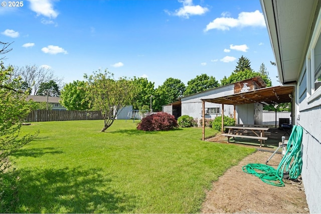view of yard with an outbuilding and fence