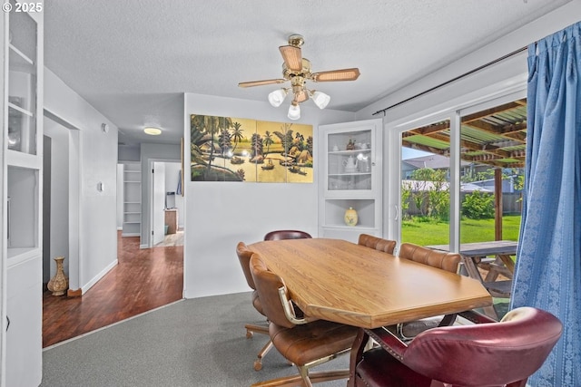 dining area featuring a textured ceiling, wood finished floors, and a ceiling fan