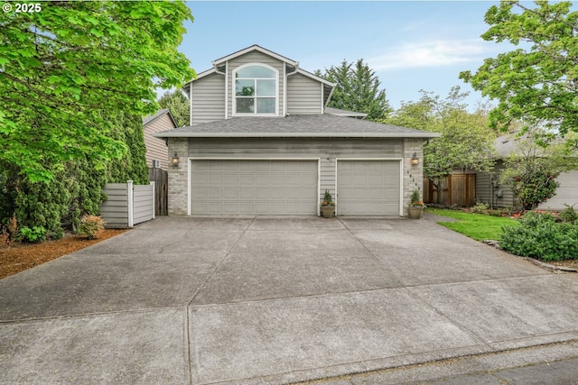 garage with fence and concrete driveway