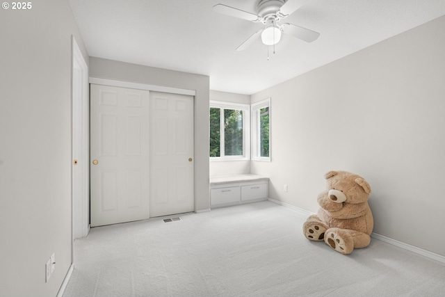 unfurnished bedroom with baseboards, visible vents, light carpet, and a closet