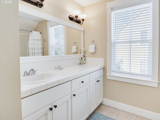2696 SW Barnacle Ave, Lincoln City, OR 97367 - full bathroom with baseboards, double vanity, tile patterned flooring, and a sink