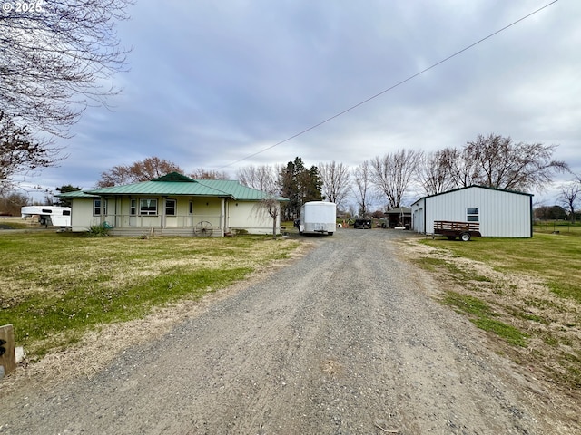 view of street with gravel driveway and a pole building