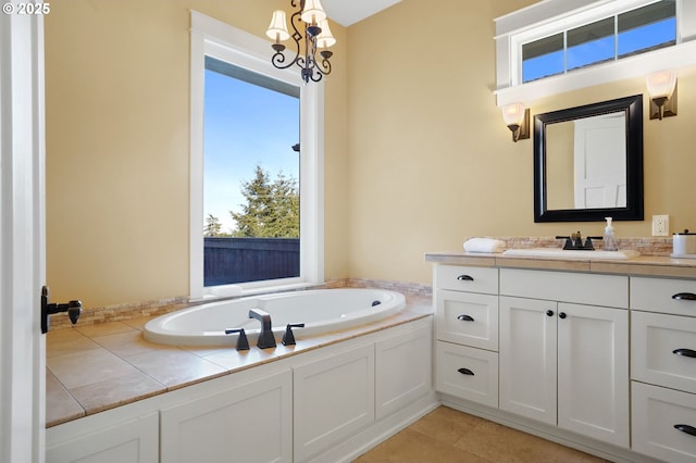 bathroom with tile patterned flooring, a chandelier, a bath, and vanity