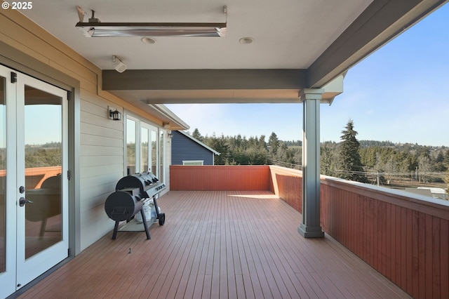 wooden terrace featuring grilling area and a wooded view