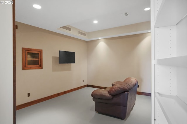 living area with baseboards, visible vents, concrete flooring, and recessed lighting