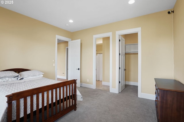 bedroom with a walk in closet, recessed lighting, a closet, carpet flooring, and baseboards