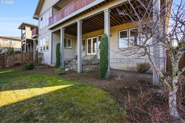 view of side of property featuring a lawn and fence