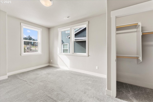 unfurnished bedroom featuring carpet, a closet, visible vents, and baseboards