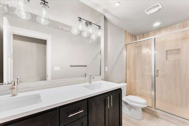 full bath featuring toilet, a sink, and visible vents