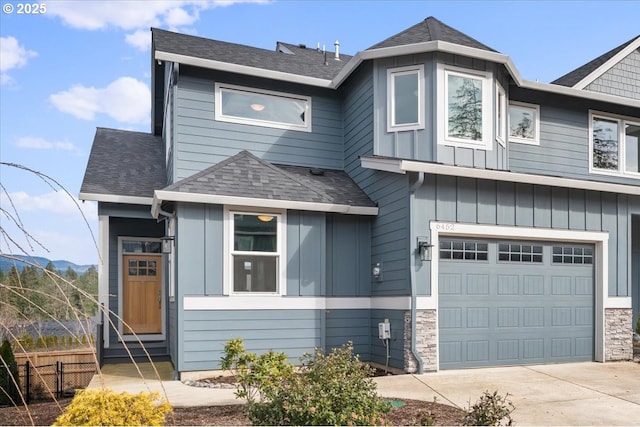 view of front facade featuring driveway, a shingled roof, an attached garage, fence, and board and batten siding