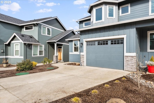 view of front of house with a garage, stone siding, board and batten siding, and concrete driveway