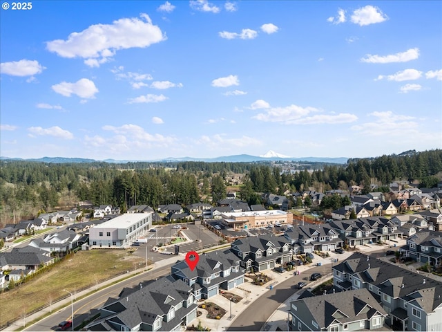 drone / aerial view with a residential view, a mountain view, and a view of trees