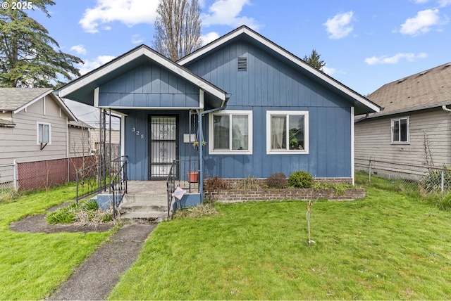 view of front of property with a front lawn and fence