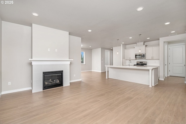 8900 S 1st St Unit 17, Ridgefield, WA 98642 - unfurnished living room featuring recessed lighting, light wood-type flooring, and a tile fireplace
