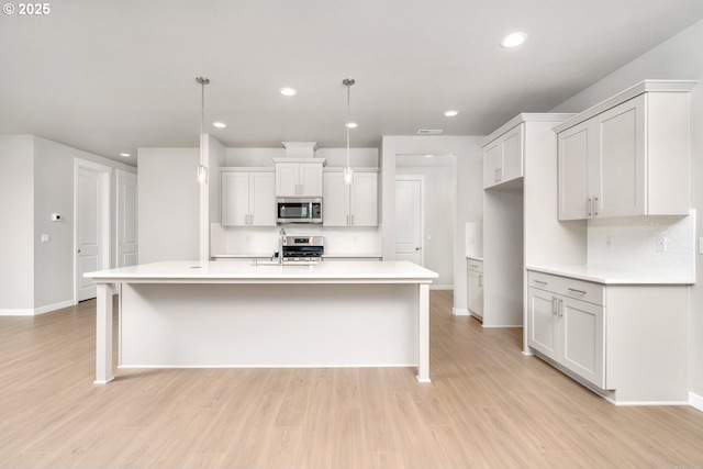 8900 S 1st St Unit 17, Ridgefield, WA 98642 - kitchen with appliances with stainless steel finishes, light wood-style flooring, light countertops, recessed lighting, and a center island with sink