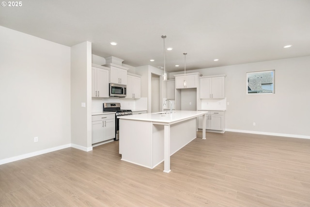 8900 S 1st St Unit 17, Ridgefield, WA 98642 - kitchen featuring stainless steel appliances, an island with sink, light wood-style floors, recessed lighting, and light countertops