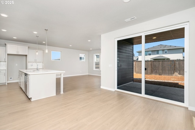 8900 S 1st St Unit 17, Ridgefield, WA 98642 - kitchen with light wood-style flooring, open floor plan, light countertops, white cabinetry, and a kitchen breakfast bar