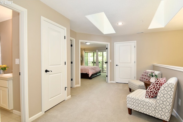 living area featuring light carpet and a skylight