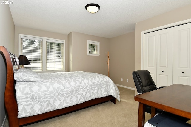 carpeted bedroom with a closet and a textured ceiling