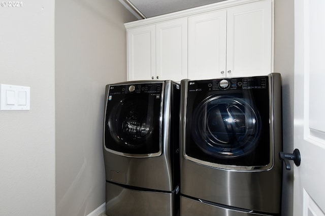 laundry room featuring cabinets and washing machine and dryer