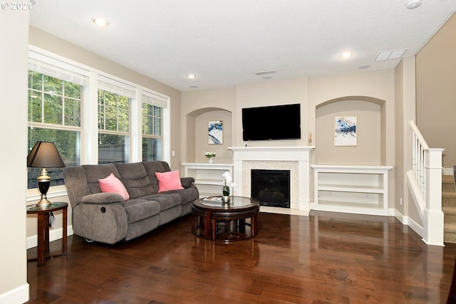 living room with dark hardwood / wood-style floors and a textured ceiling