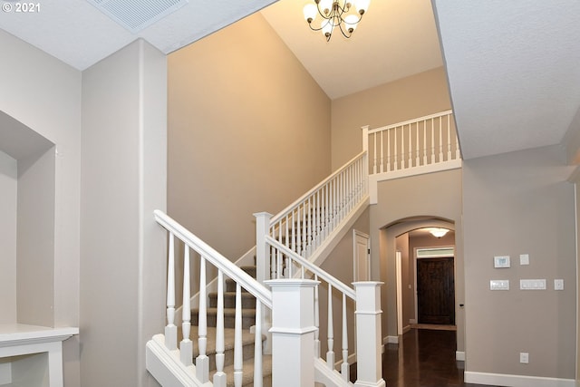 stairway with a towering ceiling and hardwood / wood-style floors