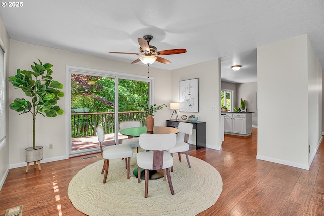 dining room featuring ceiling fan, wood finished floors, and baseboards