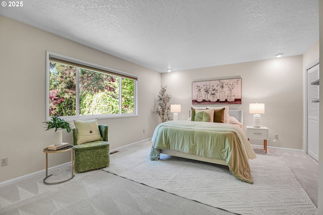 bedroom with carpet floors, a textured ceiling, and baseboards