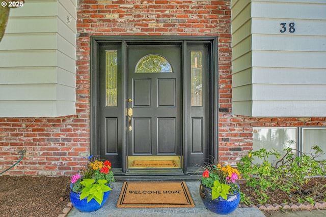 entrance to property featuring brick siding