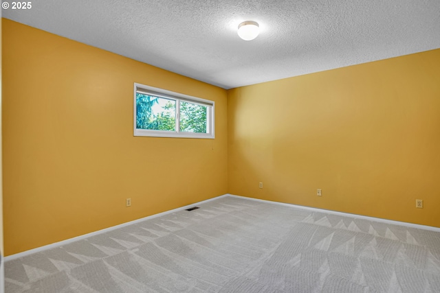 unfurnished room with a textured ceiling, light carpet, and baseboards