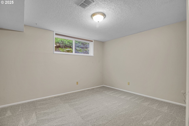 carpeted spare room featuring a textured ceiling and baseboards