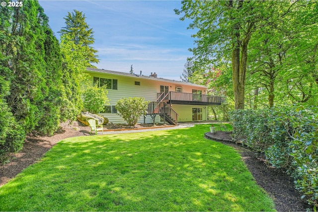 rear view of property with stairs, a wooden deck, and a yard