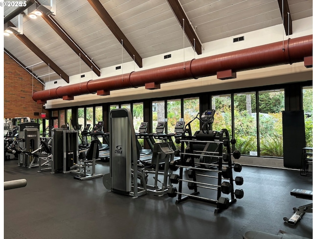 gym with beam ceiling, wood ceiling, healthy amount of natural light, and high vaulted ceiling