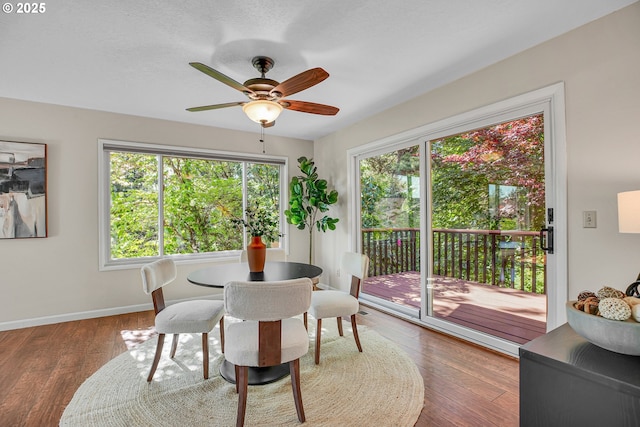 dining room with a ceiling fan, baseboards, and wood finished floors