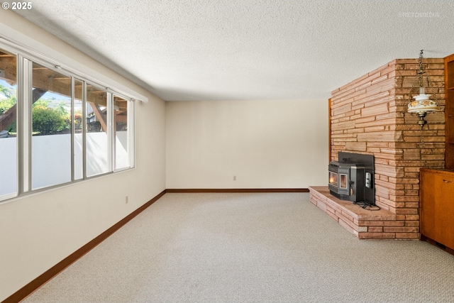 1810 D St, Forest Grove, OR 97116 - unfurnished living room featuring carpet, a wood stove, baseboards, and a textured ceiling