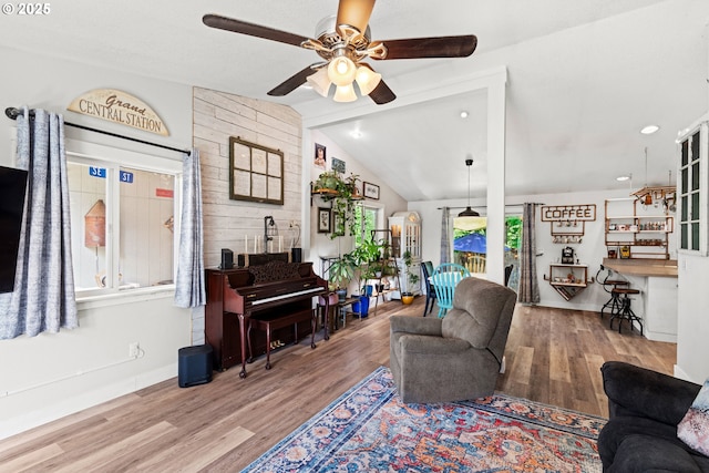 living room featuring a ceiling fan, wood finished floors, and lofted ceiling