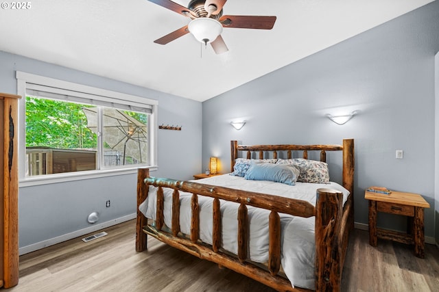 bedroom with vaulted ceiling, wood finished floors, baseboards, and ceiling fan