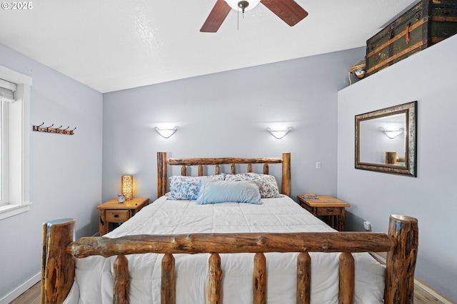 bedroom featuring wood finished floors, baseboards, and a ceiling fan