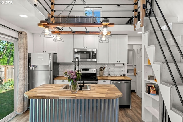 kitchen with wood counters, stainless steel appliances, dark wood-type flooring, and backsplash