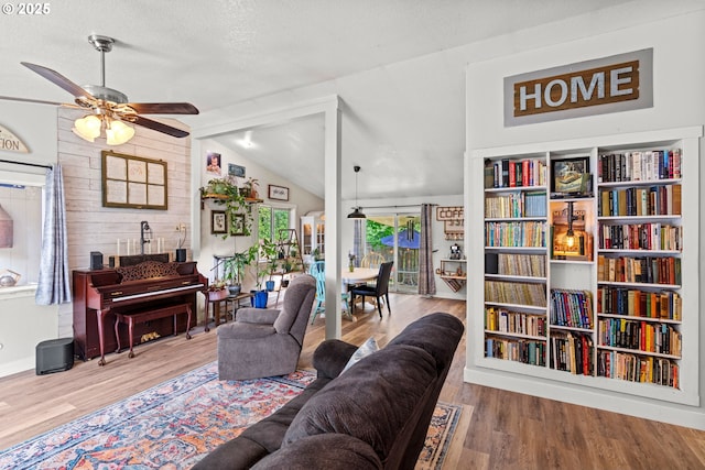 living room with lofted ceiling, a ceiling fan, and wood finished floors