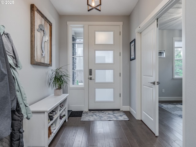 foyer with dark wood-style floors and baseboards