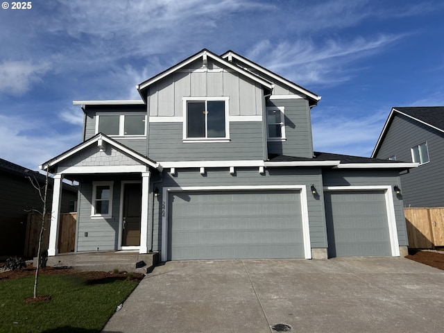 view of front of home featuring board and batten siding, concrete driveway, fence, and an attached garage