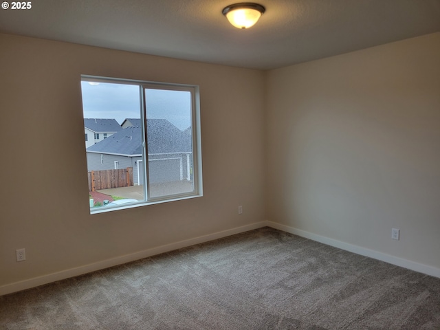 empty room featuring carpet floors and baseboards