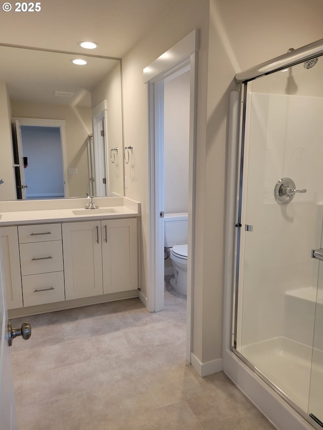 bathroom featuring a stall shower, vanity, toilet, and recessed lighting