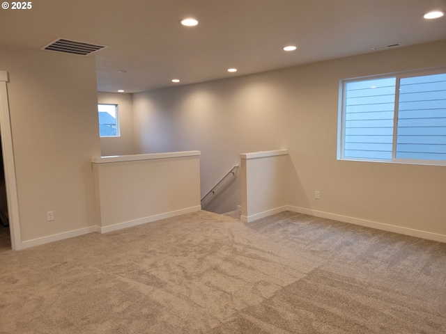 carpeted spare room featuring baseboards, visible vents, and recessed lighting