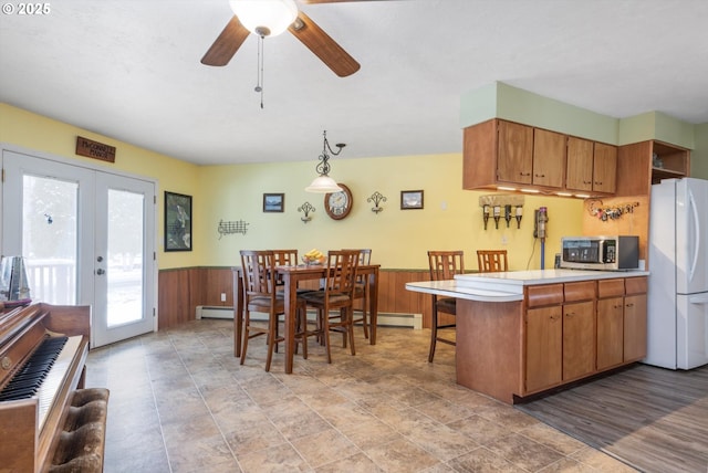 kitchen featuring freestanding refrigerator, light countertops, french doors, wainscoting, and stainless steel microwave