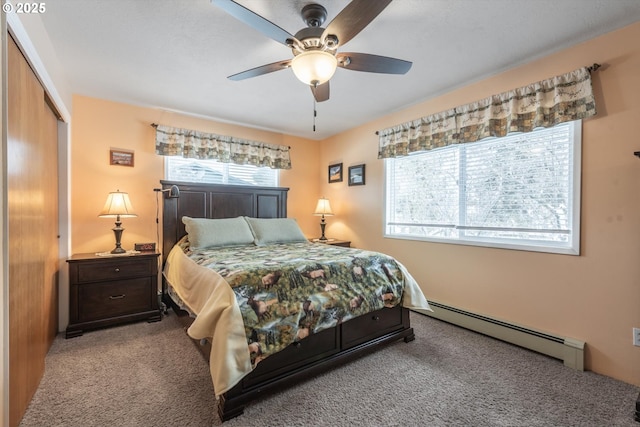 carpeted bedroom featuring a closet, a baseboard heating unit, and a ceiling fan