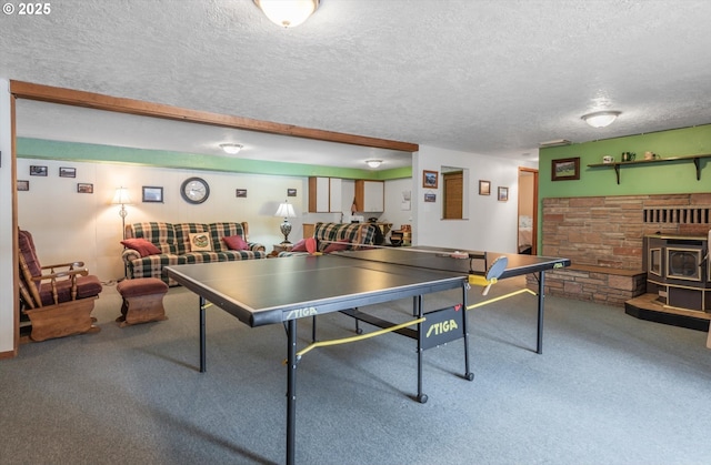 game room with a wood stove, carpet floors, and a textured ceiling