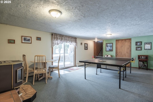 recreation room with baseboards, carpet, and a textured ceiling